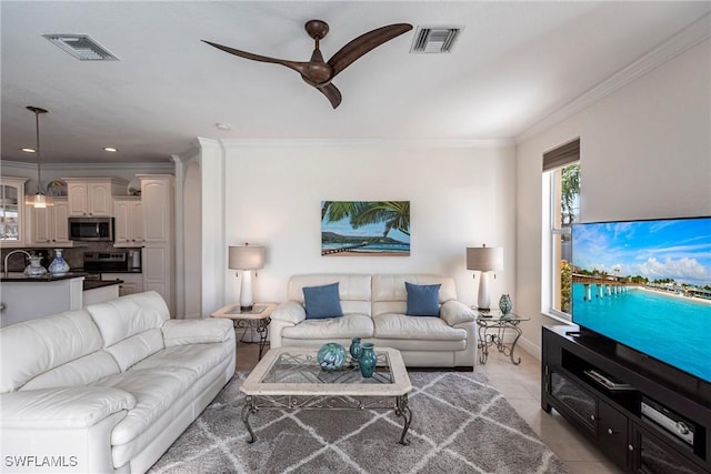 living room with crown molding, light tile patterned flooring, visible vents, and ceiling fan