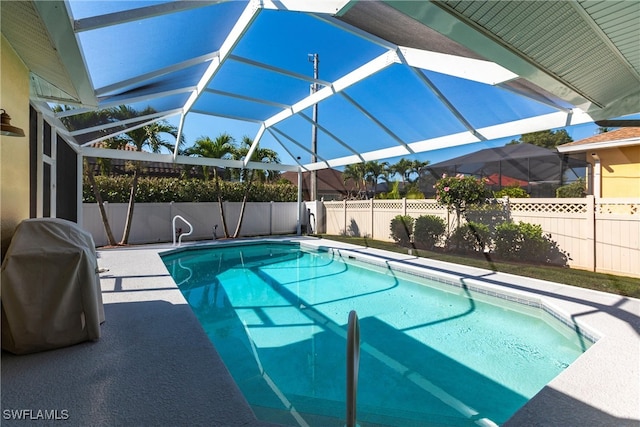 view of pool featuring area for grilling, a patio, a fenced backyard, glass enclosure, and a fenced in pool