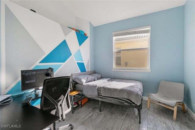 bedroom with baseboards and wood finished floors