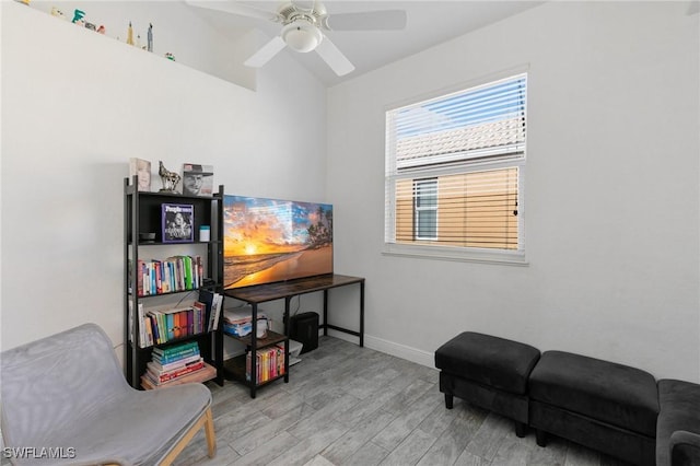 sitting room with a ceiling fan, light wood-style floors, and baseboards