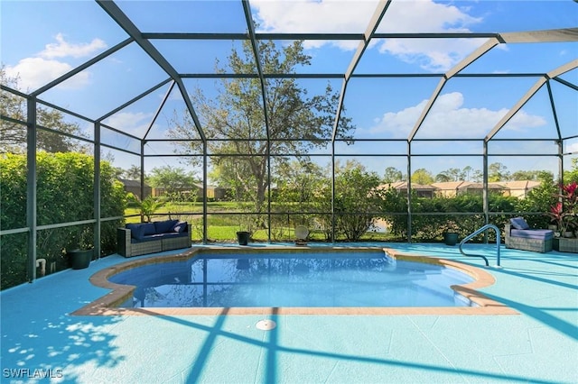 outdoor pool with glass enclosure, a patio area, and an outdoor hangout area