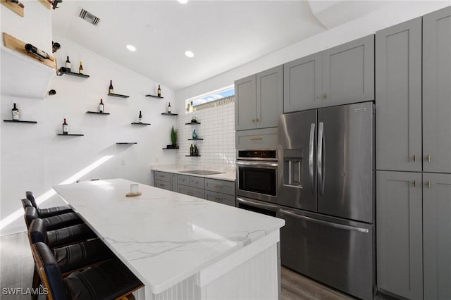 kitchen featuring visible vents, gray cabinets, open shelves, appliances with stainless steel finishes, and light stone countertops