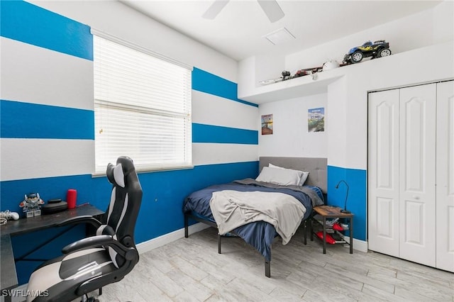 bedroom with a ceiling fan, wood finished floors, a closet, and baseboards