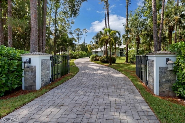 exterior space featuring decorative driveway and a gate