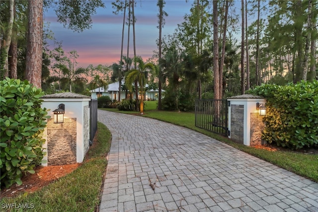 view of street with decorative driveway and a gated entry