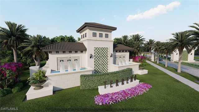 back of property with a tiled roof, a yard, and stucco siding