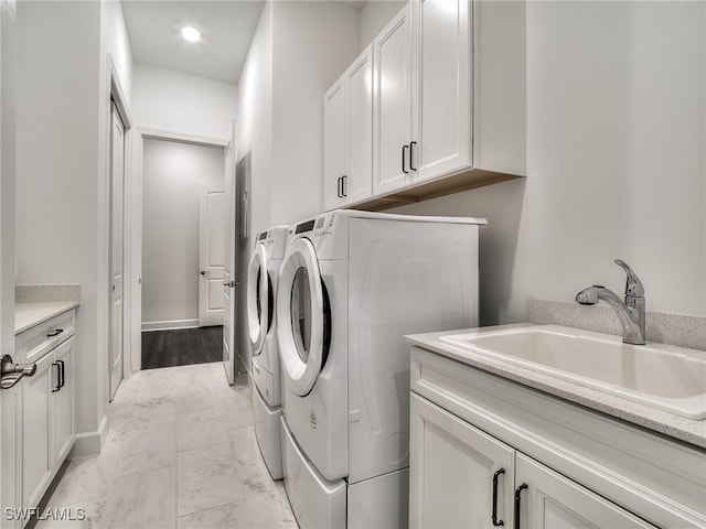 washroom featuring cabinet space, washer and dryer, marble finish floor, and a sink