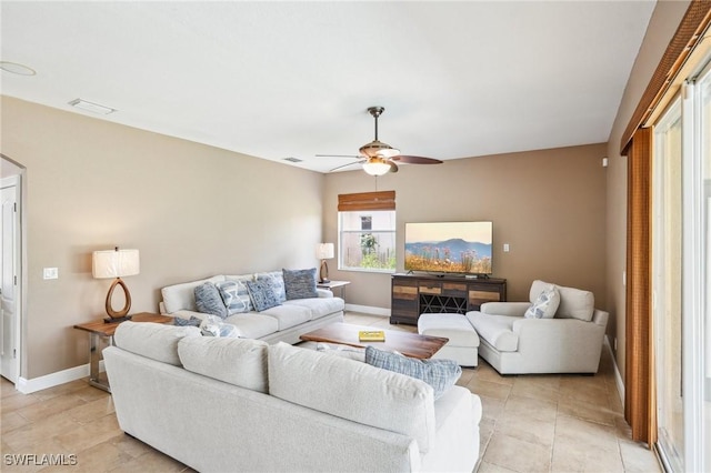 living room featuring light tile patterned flooring, baseboards, visible vents, and ceiling fan