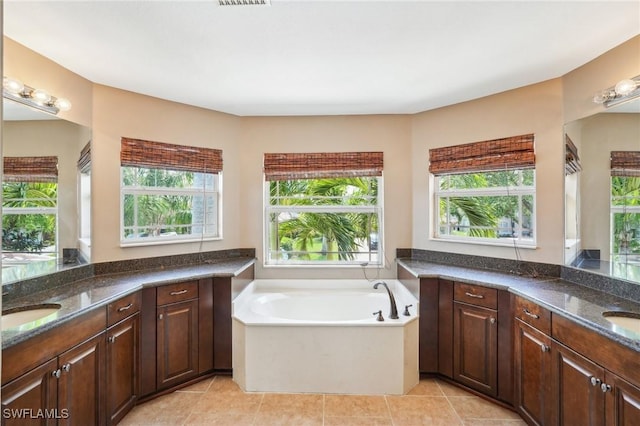 bathroom featuring tile patterned floors, a sink, a garden tub, two vanities, and visible vents