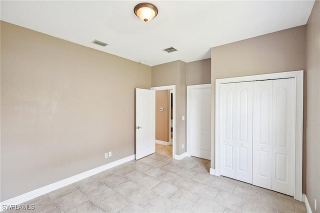 unfurnished bedroom featuring a closet, baseboards, and visible vents