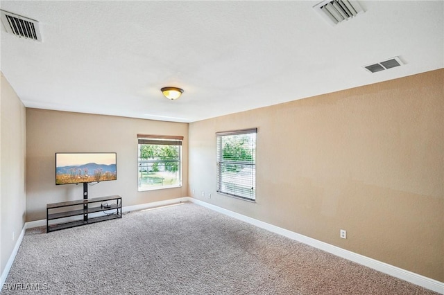 unfurnished room with baseboards, carpet flooring, and visible vents