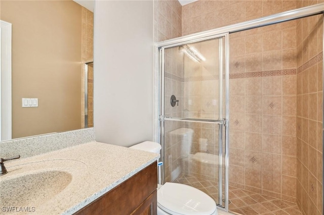 full bath featuring vanity, toilet, and a shower stall