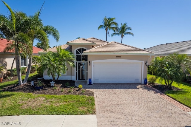 view of front of home featuring a tiled roof, stucco siding, an attached garage, and decorative driveway