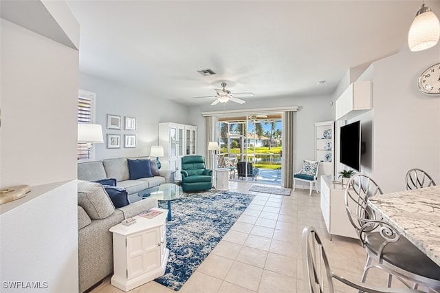 living area with light tile patterned floors, visible vents, and ceiling fan