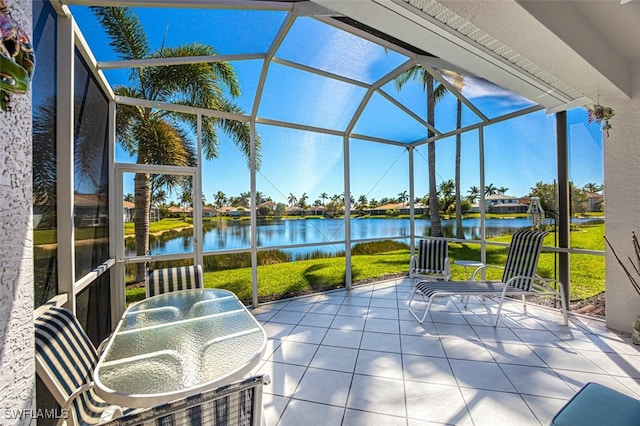 view of patio featuring a lanai and a water view