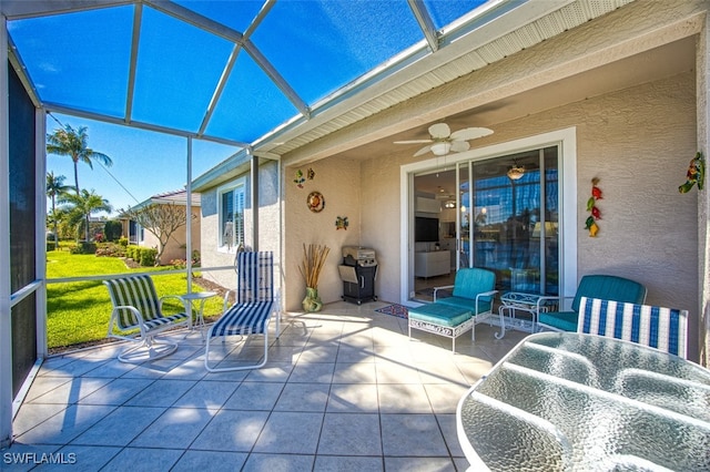 view of patio with a lanai, area for grilling, ceiling fan, and outdoor lounge area