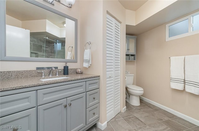 full bathroom featuring toilet, a closet, a shower stall, baseboards, and vanity