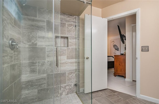 bathroom featuring tile patterned floors, baseboards, and a shower stall