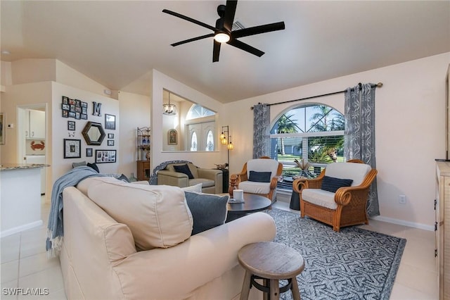 living area featuring vaulted ceiling, light tile patterned flooring, a ceiling fan, and baseboards