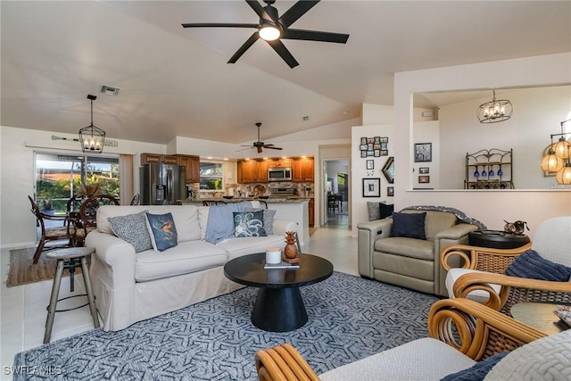 living area featuring vaulted ceiling, light tile patterned flooring, ceiling fan with notable chandelier, and visible vents