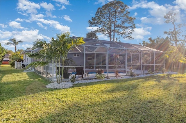 rear view of property with an outdoor pool, a yard, a lanai, and a patio area