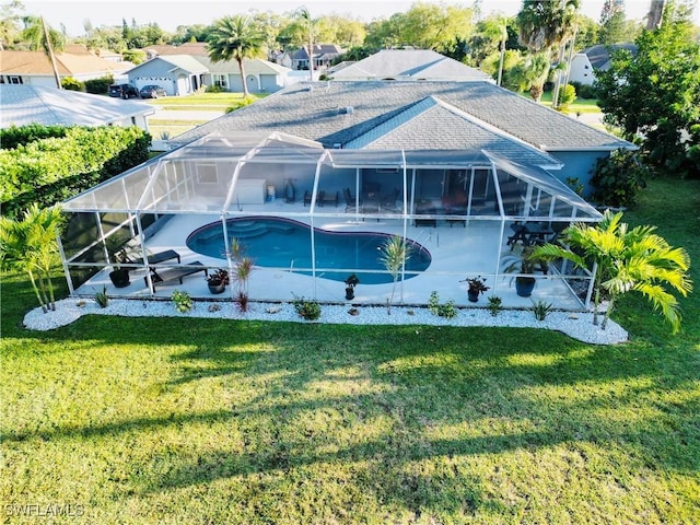 pool featuring a lanai, a patio area, and a lawn