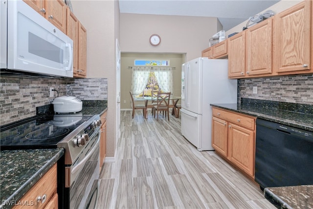 kitchen with tasteful backsplash, white appliances, and light wood-style floors