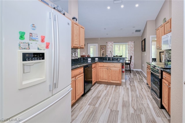 kitchen featuring white appliances, visible vents, a peninsula, light wood-style flooring, and a sink