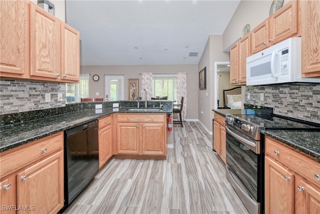 kitchen featuring stainless steel electric range oven, white microwave, a peninsula, a sink, and black dishwasher