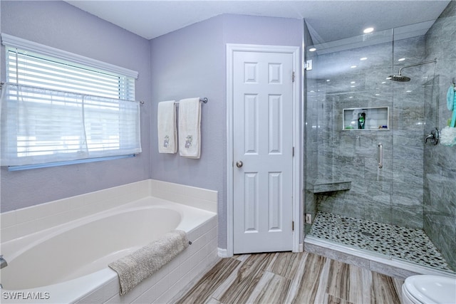 bathroom featuring a stall shower, toilet, and a garden tub