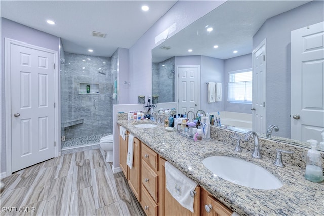 bathroom featuring visible vents, a shower stall, toilet, and a sink