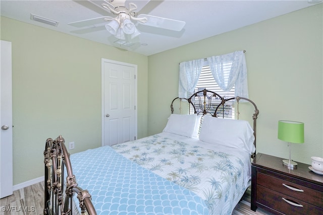 bedroom with visible vents, wood finished floors, and a ceiling fan