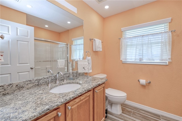 full bathroom with baseboards, wood tiled floor, toilet, a stall shower, and vanity