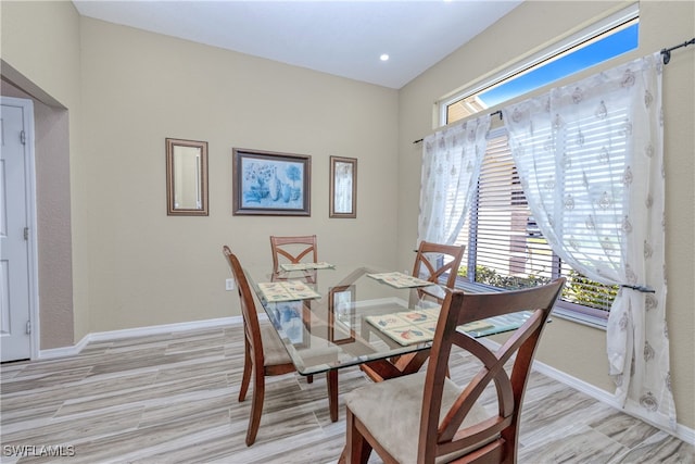 dining area featuring baseboards and light wood finished floors