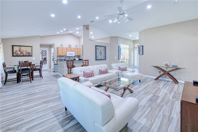 living area with vaulted ceiling, recessed lighting, light wood-type flooring, and ceiling fan