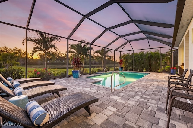 pool featuring glass enclosure and a patio