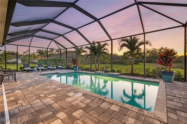 outdoor pool with glass enclosure and a patio area