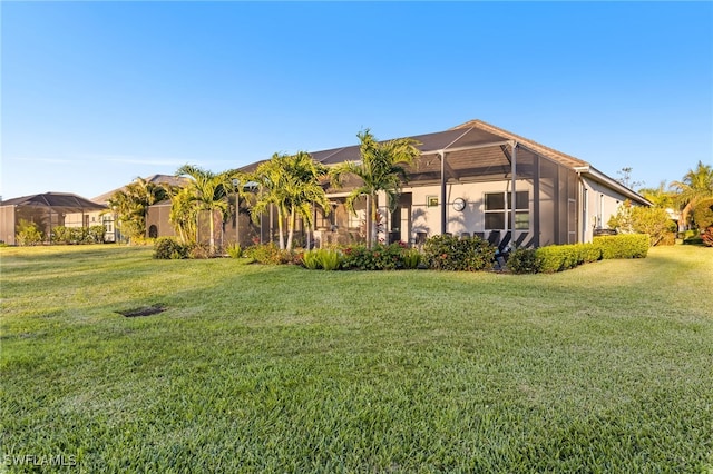 view of front facade featuring glass enclosure and a front lawn