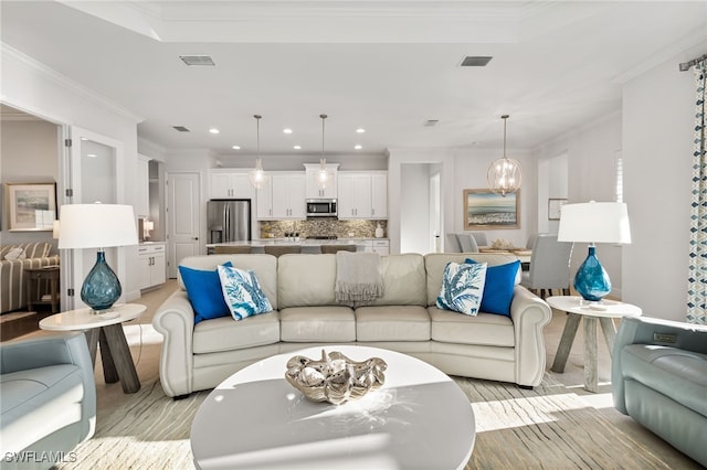 living area with recessed lighting, visible vents, and crown molding