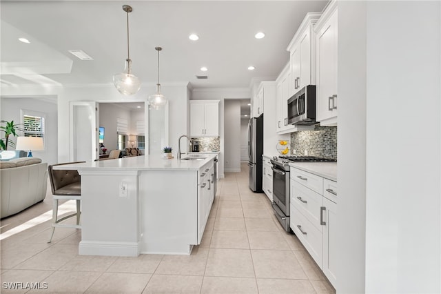 kitchen featuring open floor plan, light countertops, light tile patterned floors, stainless steel appliances, and a sink