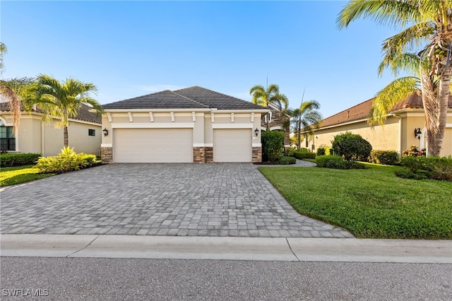 view of front of property with stucco siding, a front lawn, decorative driveway, stone siding, and an attached garage