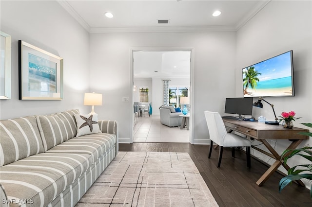 living room with visible vents, baseboards, wood finished floors, and crown molding