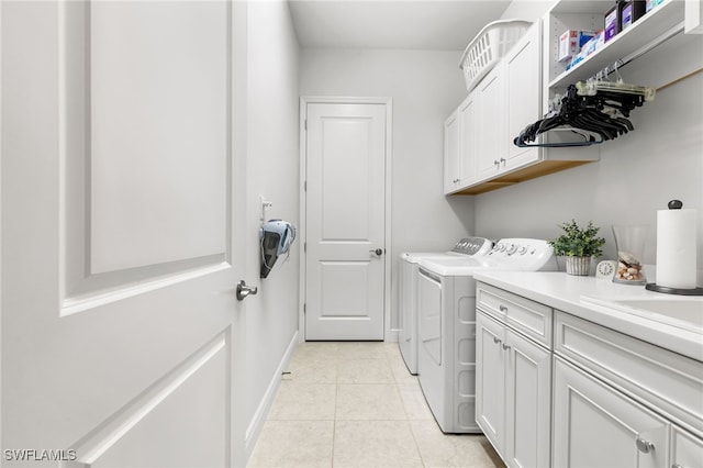 clothes washing area featuring washer and dryer, baseboards, cabinet space, and light tile patterned flooring