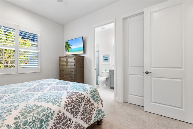 bedroom featuring connected bathroom and carpet