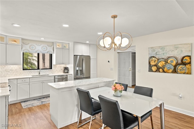 dining area with recessed lighting, a notable chandelier, and light wood finished floors