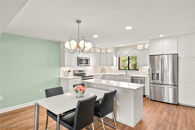 kitchen with glass insert cabinets, tasteful backsplash, appliances with stainless steel finishes, and light wood-style flooring