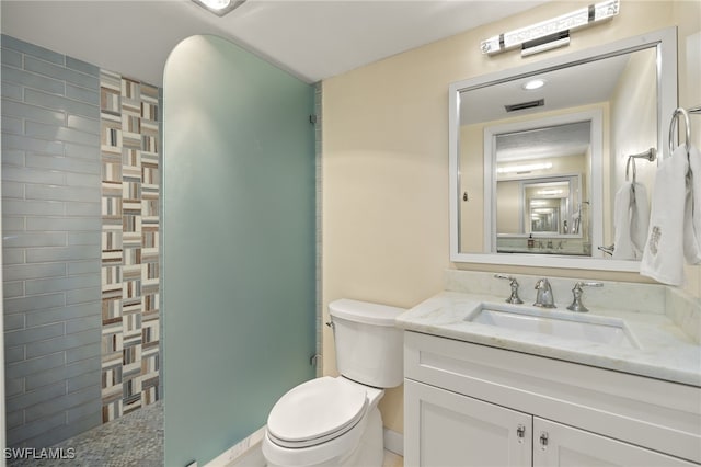 full bath featuring visible vents, a walk in shower, toilet, and vanity