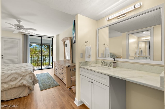 ensuite bathroom with vanity, wood finished floors, a ceiling fan, floor to ceiling windows, and ensuite bathroom