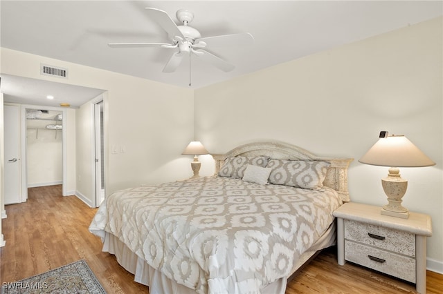 bedroom featuring wood finished floors, visible vents, a closet, and baseboards