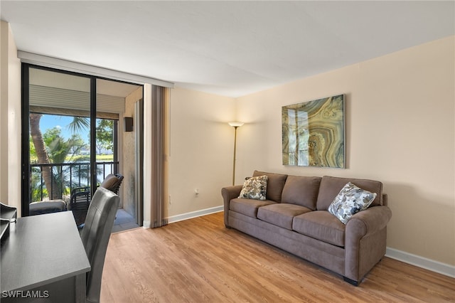 living area featuring light wood-type flooring, baseboards, and expansive windows